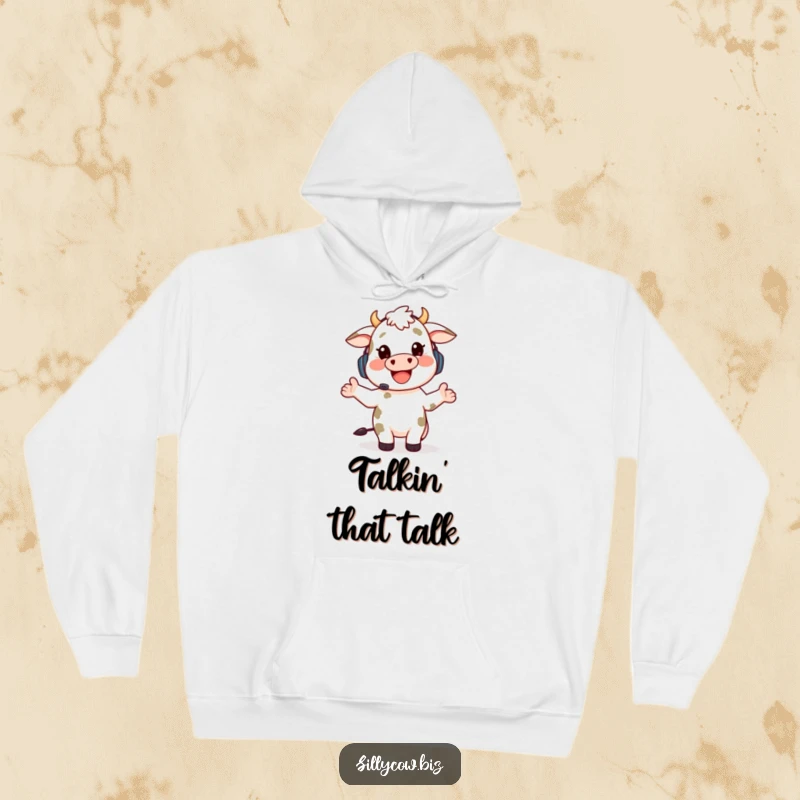 Funny hoodie featuring a happy cow character wearing a headset, gesturing enthusiastically while talking, providing warmth and humor.